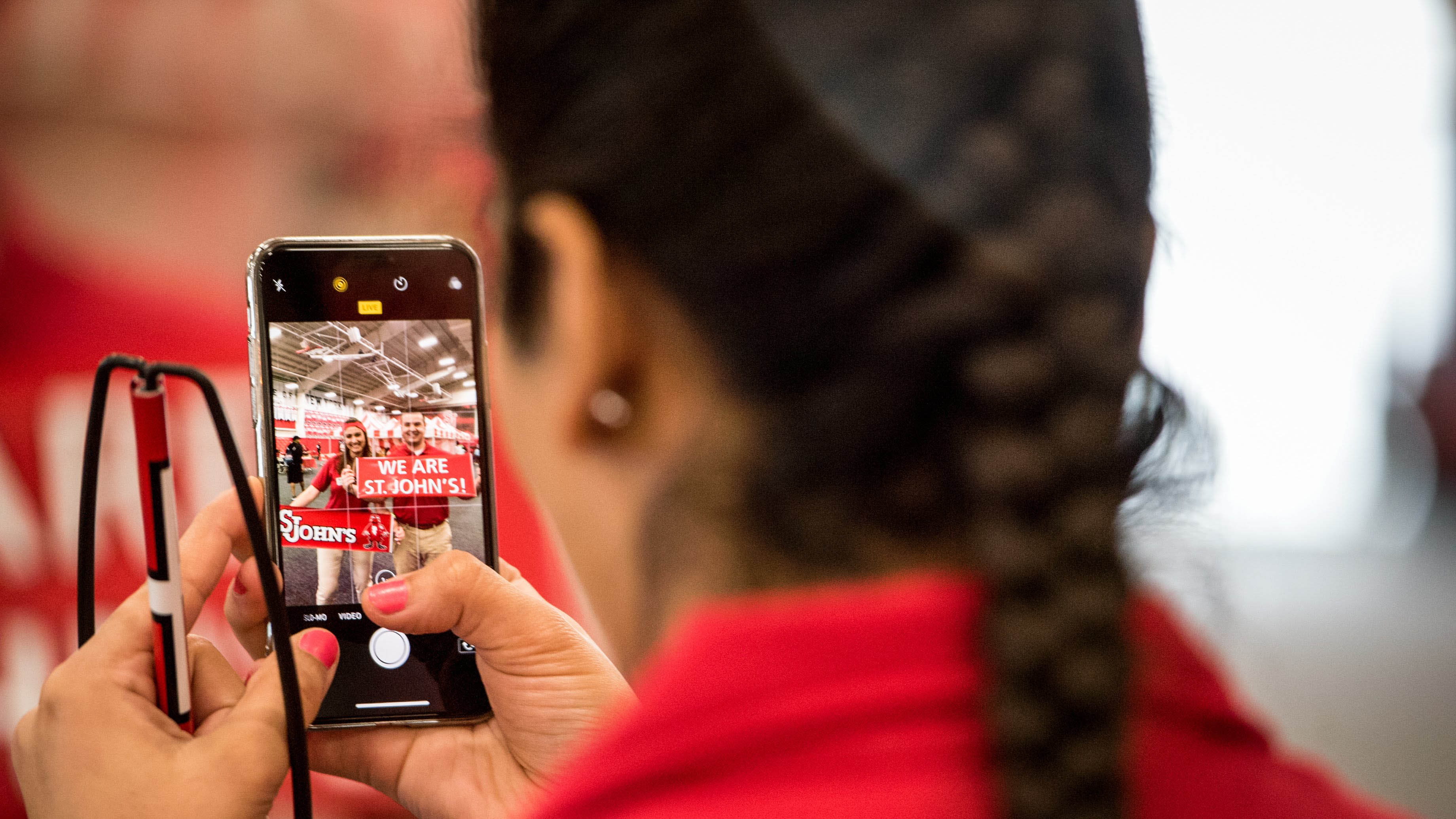 Female student taking photo of other students with her cell phone