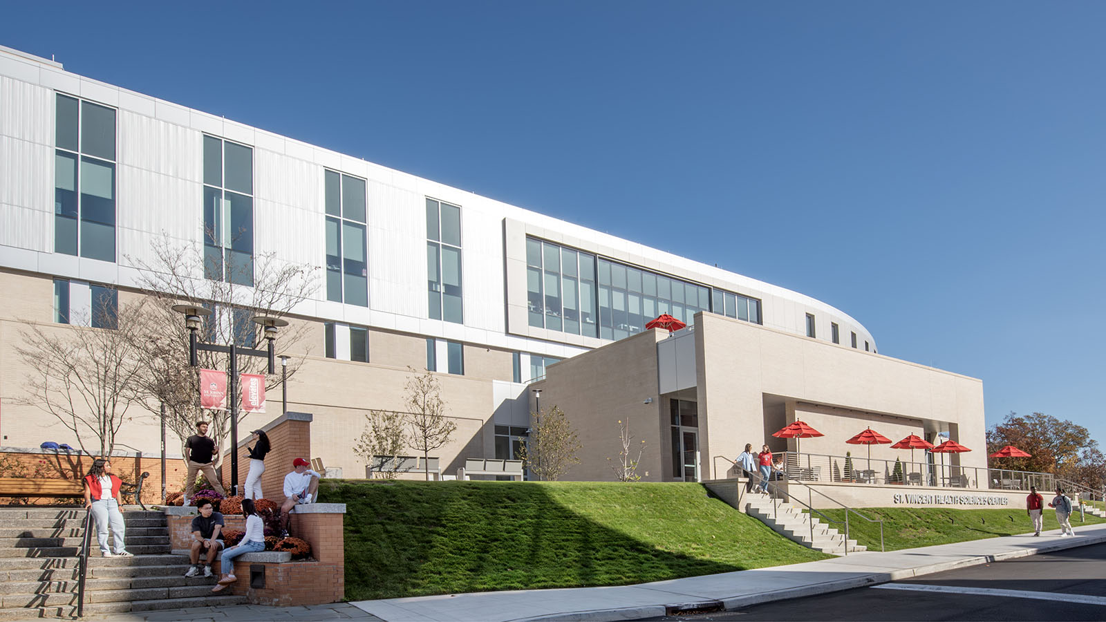 St. John's University Health Sciences Center Exterior of building with students studying at tables