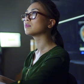 Woman with glasses looking at brain scans on computers