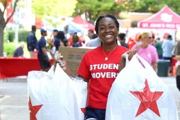 Female student mover carrying Macy bags