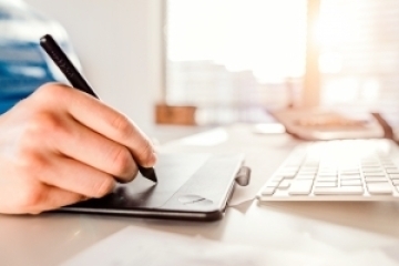 man writing on tablet