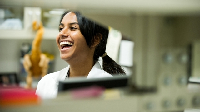 Female Student Laughing in Lab Coat