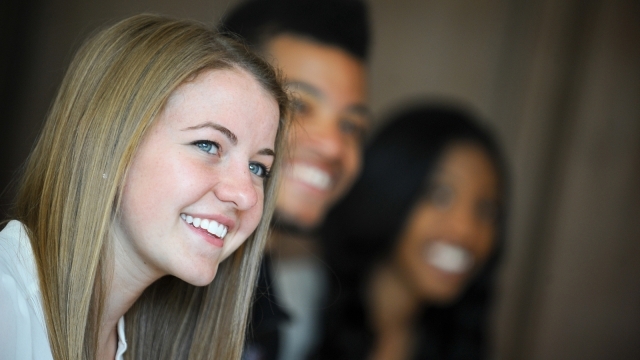 three students smiling at camera