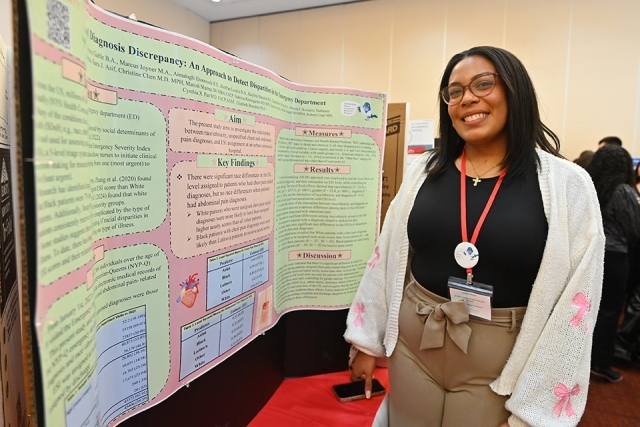 Student standing by their poster