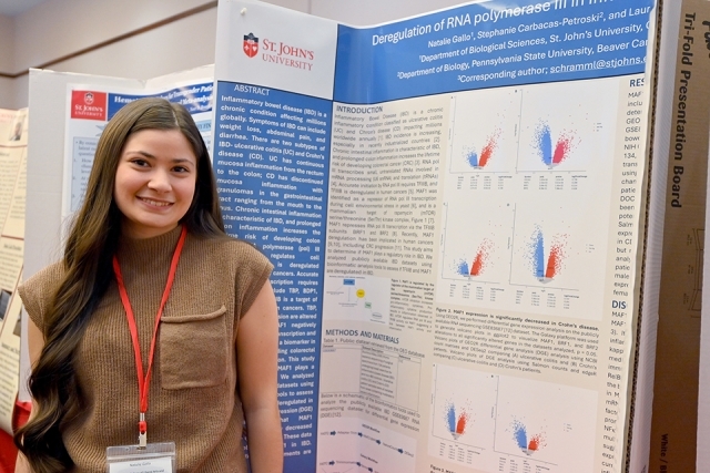 Student standing by their poster