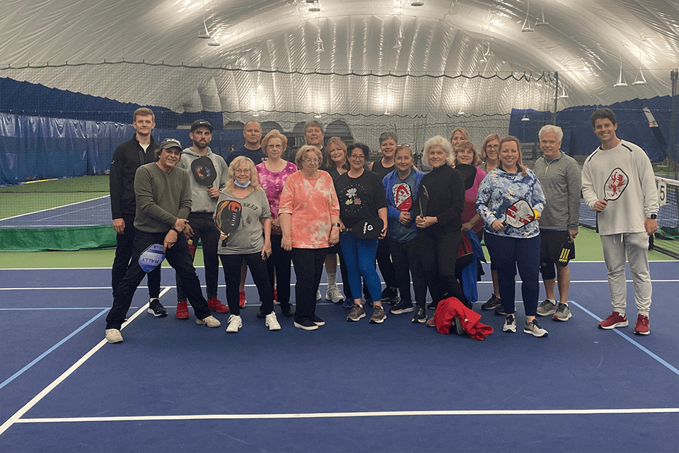 St. John's alumni pose for a group picture on the pickleball court